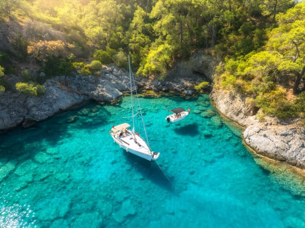 Aerial view of beautiful yacht and sailboat on the sea at sunrise